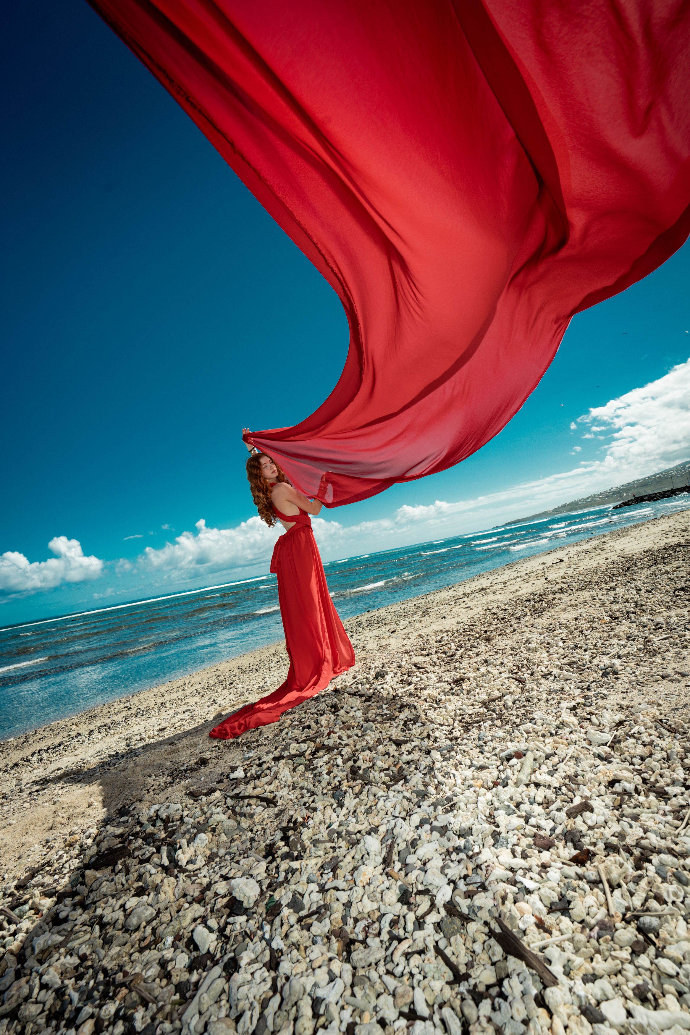 Séance photo en robe rouge sur la plage